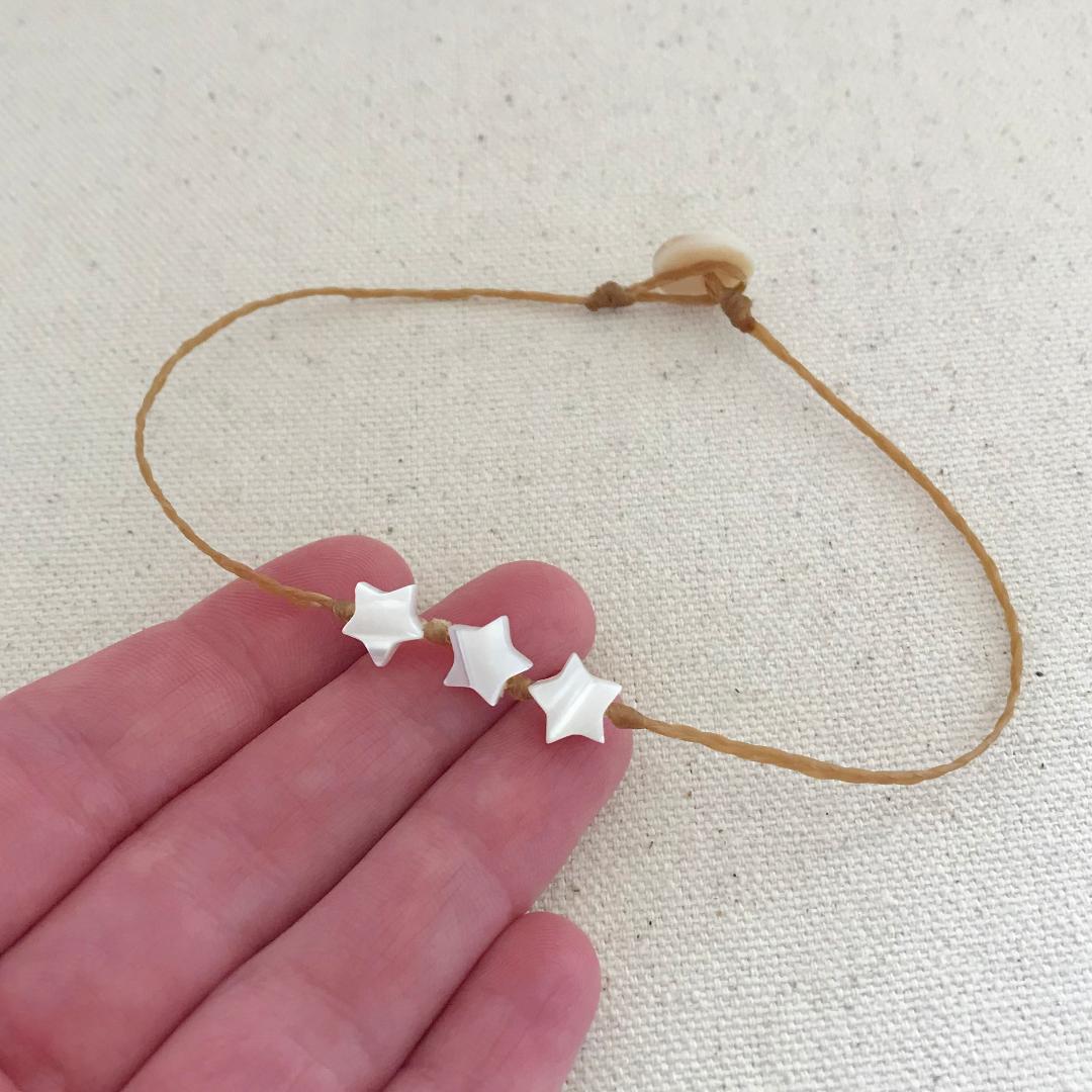 beach boho style anklet with three 7mm mother of pearl stars knotted onto braided waxed cord